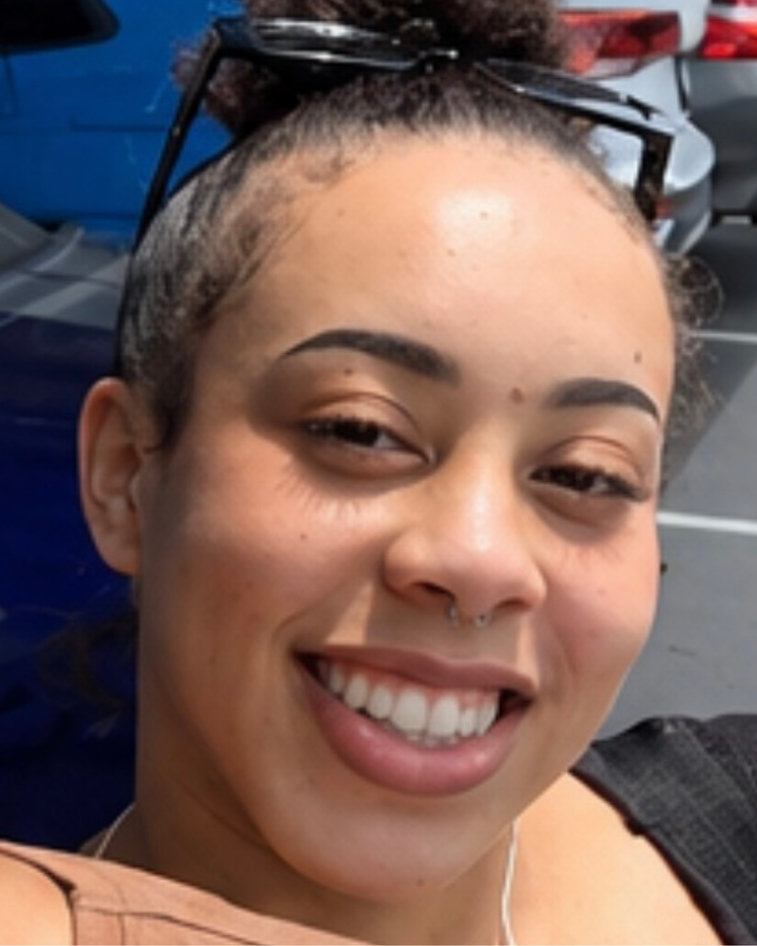 Jazzie smiling with sunglasses on her head